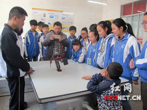 湘乡一职的科技志愿者正在给前来观摩的学生演示机器人的表演