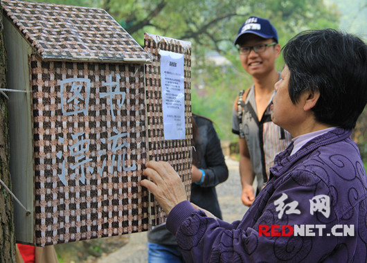 一位老奶奶刚刚打完太极就被小书箱吸引了