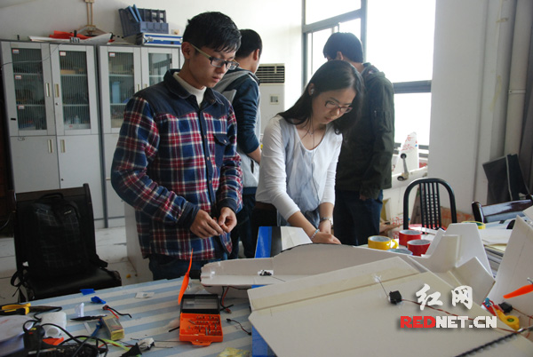 大学生创新实验中心，两名学生正在制作固定翼飞机。