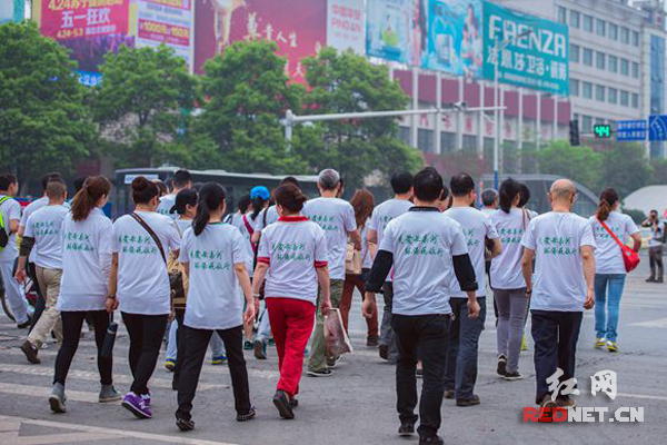 参与徒步宣传活动的志愿者们上街宣传税收与环保。
