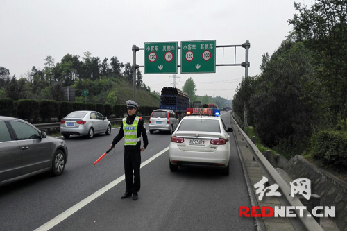 高速交警在事故后方示警，提醒过往车辆有序通行