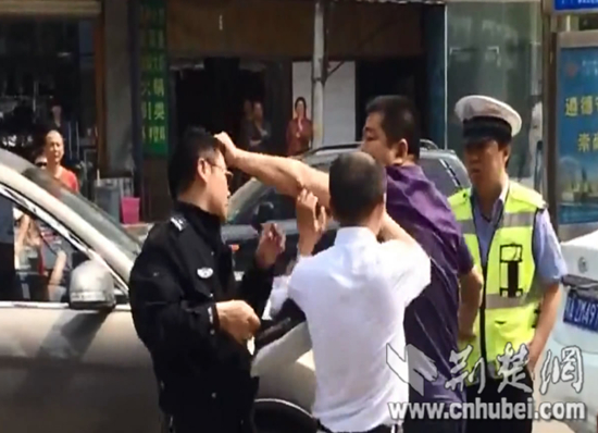 王某揪住交警头发（视频截图）