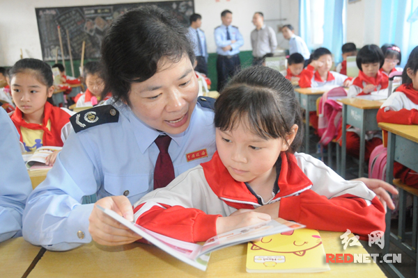 税务干部辅导小学生了解税收。