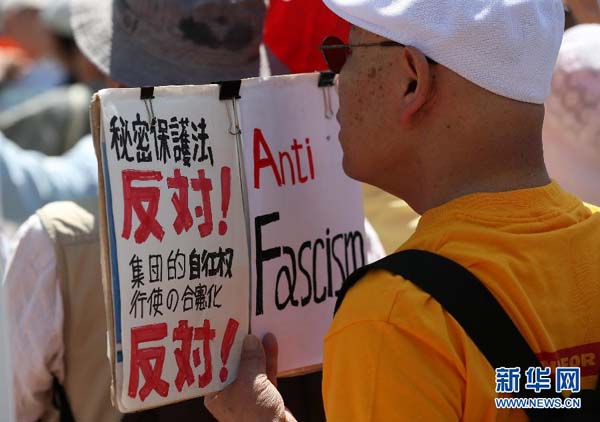 　　 5月3日，在日本横滨，示威者手持“反对秘密保护法，反对集体自卫权”的标语，抗议首相安倍晋三企图修改和平宪法。当日是日本第68个宪法纪念日，约三万日本民众在横滨参加保护和平宪法的集会，其中数千人举行了示威游行。 新华社记者刘天摄