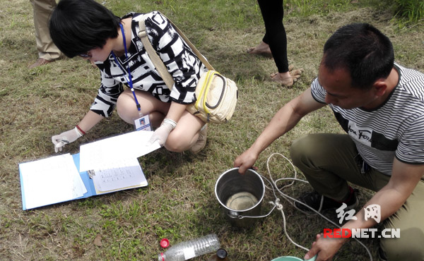 在湖南中和制药有限公司，对污水排放总排口进行采样，执法人员现场记录。