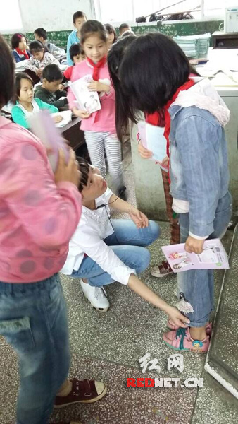 老师在逐个询问学生衣裤厚薄、干湿情况