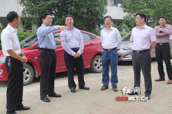 道县县委书记胡先荣（左二）在道县六中给省教育厅党组成员、省委教育工委委员王建华（左三）介绍教师公租房建设情况。 