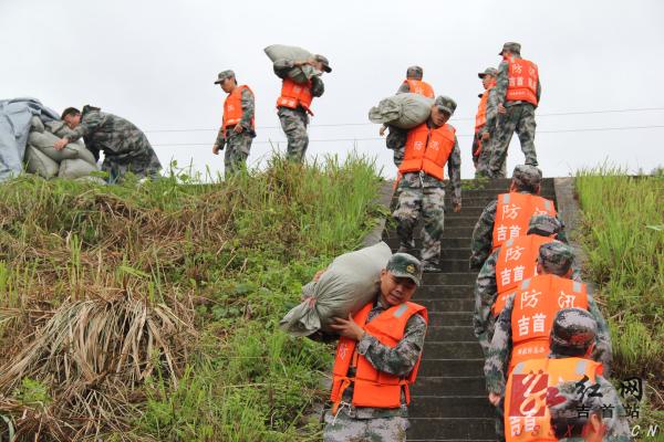 应急抢险队正在搬运沙袋处置坝体渗漏