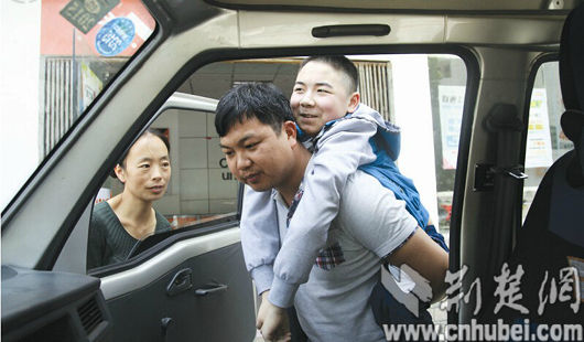 罗红的儿子患肌无力，孙万龙每天都背着90多斤的他上下车。