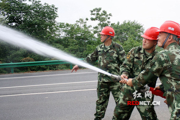 2015年5月13日，湖南省涟源市桥头河镇消防队队员们在进行消防训练。 