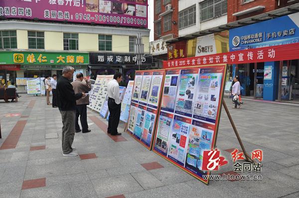 群众驻足观看应急知识宣传展板