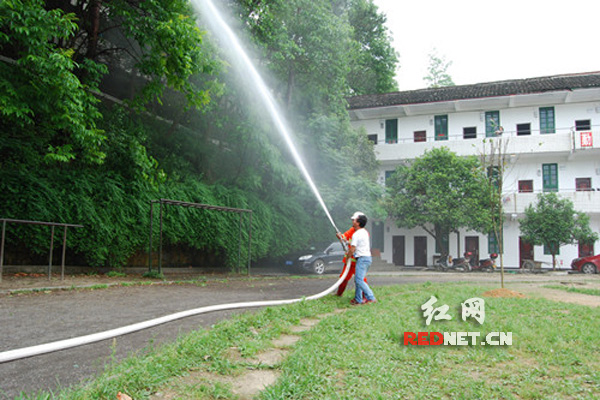 消防员和牙屯堡中学老师进行水枪喷射操作