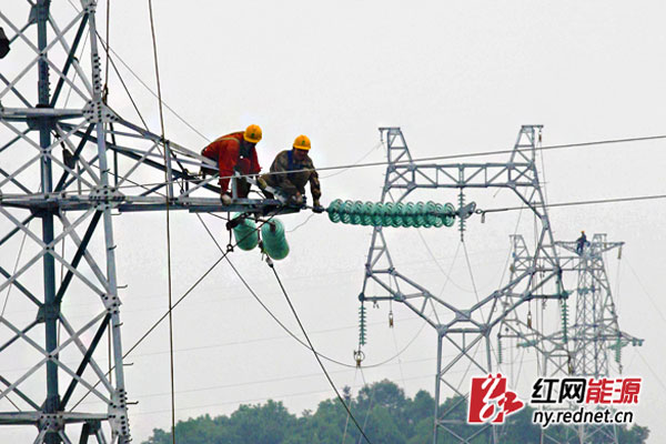 电力工人在高空固定牵引绳、安装绝缘子。