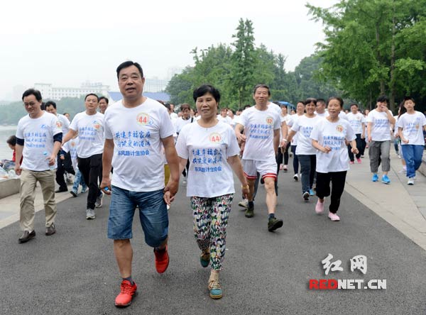 长沙开福区东风路街道百户家庭成员们手牵手，开步走，重温“一起走过的日子”。