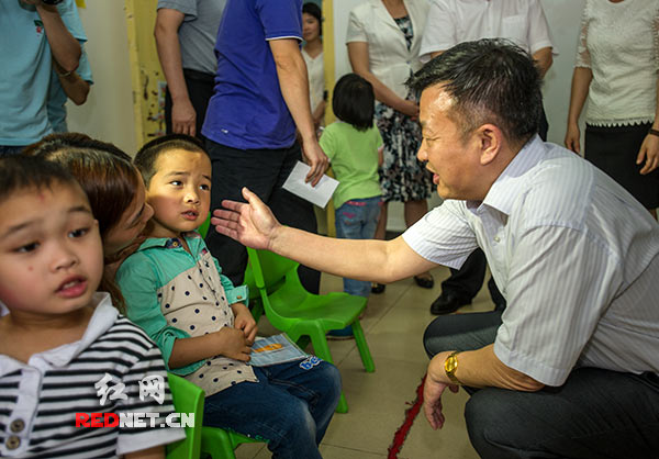 湖南省人大常委会副主任谢勇[右一]看望在长沙市爱萌特殊儿童康复中心接受康复训练的自闭症儿童。