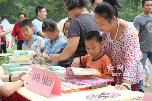 家长陪同孩子在展台阅读正版书籍