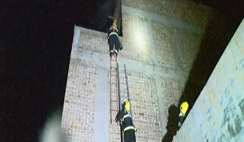 指导员杨科璋脱掉战斗鞋，利用挂钩梯赤脚爬上5楼，营救被困人员。