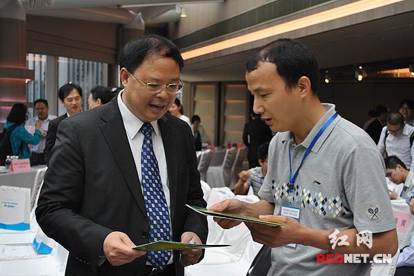 湖南省副省长张剑飞[左]与客商进行交流。