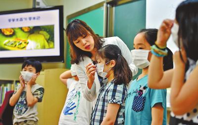 6月3日，在韩国首尔一所小学，老师在MERS预防课上给学生戴口罩。新华/法新