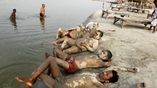 印度高温持续酷热难耐民众恒河消暑涂泥巴降温（图）