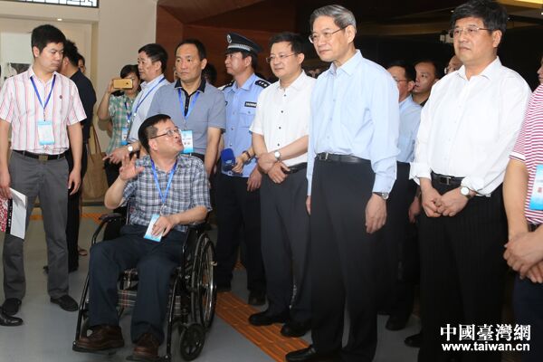 　　中共中央台办、国务院台办主任张志军与福建省残联副理事长杨小波（坐轮椅者）亲切交流。（中国台湾网何建峰摄）