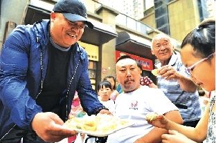 　@钢子请馅饼店周围的居民品尝自己的“小钢饼”