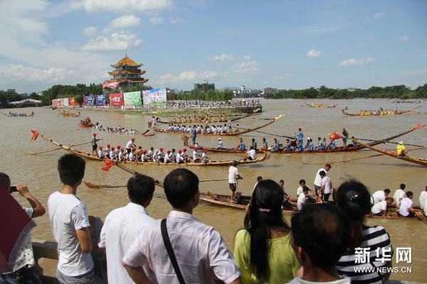 6月16日，人们在岸边观看道县龙船赛。