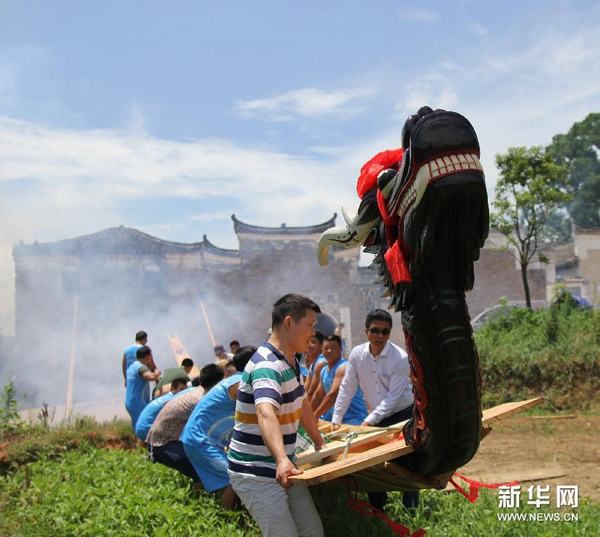 6月15日，湖南道县寿雁镇十里桥村村民将龙船抬到河边，准备参加一年一度的道县龙船赛。