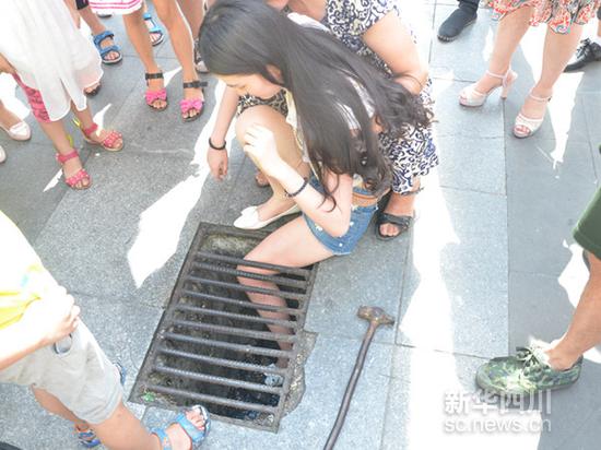 绵阳女孩走路玩手机太专心 腿卡进下水道