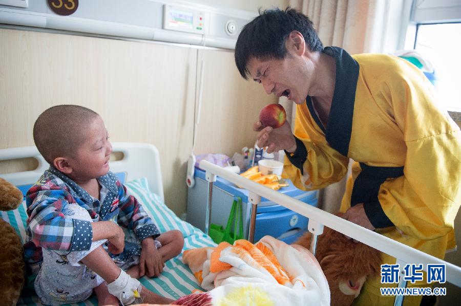  朱克良 右 在龙龙的病床旁拿着桃子模仿孙悟空