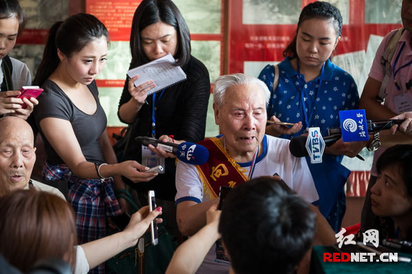 96岁的抗战老兵唐昆山含泪向海峡两岸联合采访团的记者们回忆战场杀敌的情景。