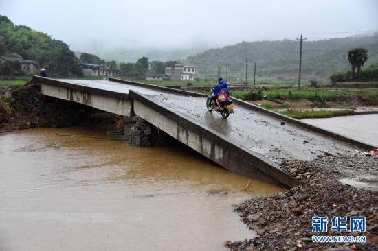 图为一辆摩托车从湖北省崇阳县山坪镇被山洪冲断的桥上驶过。新华社记者 郝同前 摄 图片来源：新华网