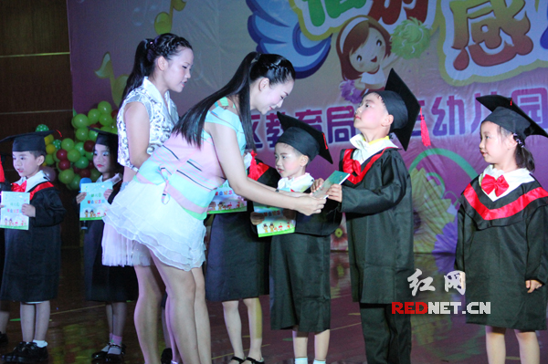 幼儿园老师给孩子们颁发人生的第一份毕业证。