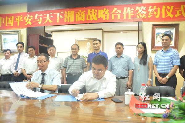 平安财险湖南分公司总经理程孝忠[左]和天下湘商投资公司董事长唐爱民签订战略合作协议。