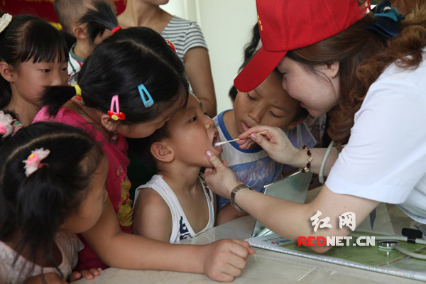 湖南省衡阳市第一人民医院的医生在衡阳市珠晖区茶山坳镇堰头村为留守儿童进行免费健康体检。