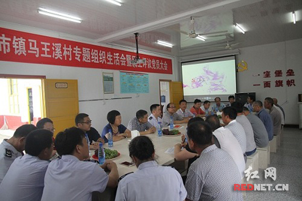 联建支部的党员们观看新农村发展专题片，并进行座谈。