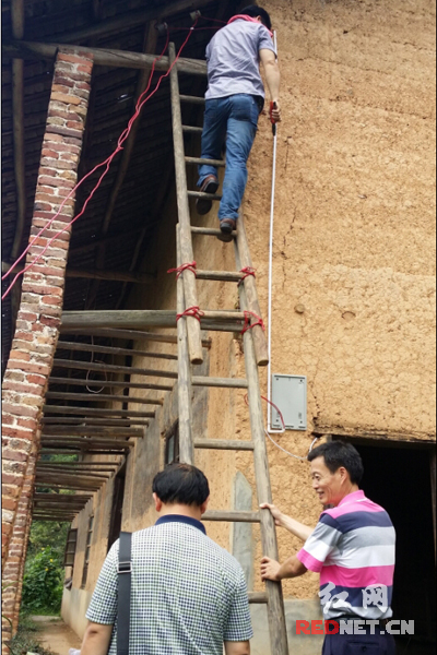 浏阳市地税局群工站队员请专业电工为安装电灯。