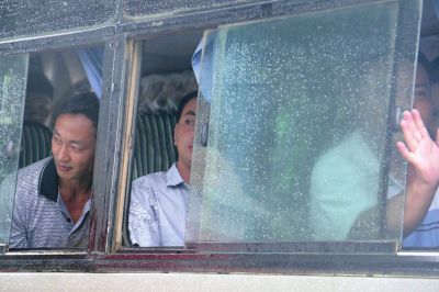 7月30日,在缅甸密支那,获释的中国伐木工人从大巴车上向外张望。新华社发