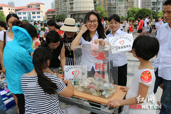 爱心人士在义卖现场购买物品并捐出善款。