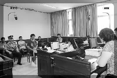 葛某坐在被告人席上