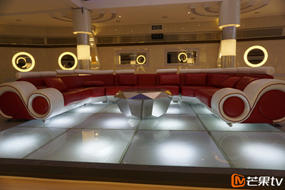 在金色和银色两种灯光的反射下,圆弧沙发显得异常有质感