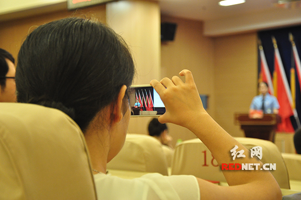 一名观众用手机记录参赛选手精彩、流利的答题过程。