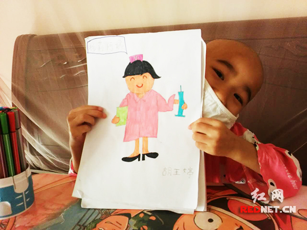 6岁的胡玉婷俏皮展示她画的护士阿姨。