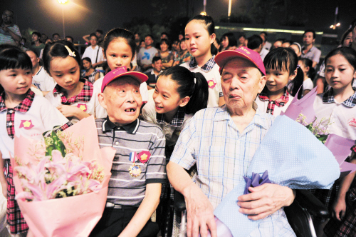 两位抗战老兵从台上下来后被孩子围住。此时，打鬼子的爷爷成了他们心中的偶像。　　长沙晚报记者 贺文兵 摄