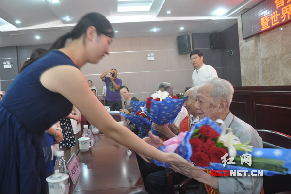湖南省文化厅系统共青团代表向老战士献花。