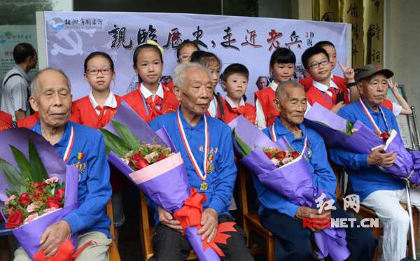 孩子们在活动现场和抗战老兵合影留念