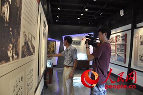 人民网记者在义桥革命烈士纪念馆采访，现场拍摄萧山区的抗战历史资料片。（记者曾伟 摄）