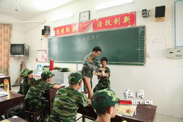 隆回一中军训学生在学习包扎固定前臂要领