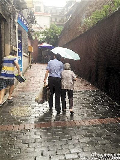 女民警雨中为拾荒老人撑伞获网友点赞（图）