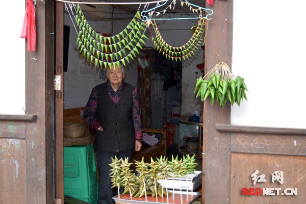 古城中有不少老人居住，她们会制作当地特有的小粽子，可以戴在脖子上做饰品。